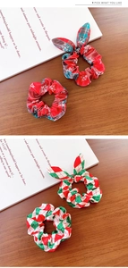 Detail von Weihnachts-Haargummis mit Schneeflockenmuster und Hasenohren auf Holz