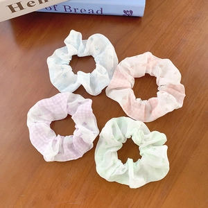 Floral and plaid hair scrunchie set in pastel colors on a rustic wooden table