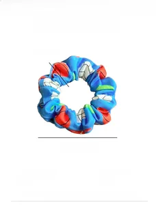 Blue fabric scrunchie with colorful ball patterns showing size and fabric texture details