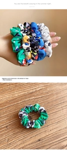 Close-up of fabric scrunchies with soccer motifs and colorful geometric patterns on wood