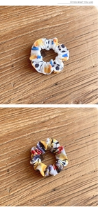 Close-up of two soccer pattern elastic fabric scrunchies on a natural wood surface