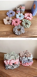 Detailed view of colorful striped scrunchies with pleated texture on a wooden desk