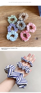Detail view of colorful striped scrunchies in olive, purple, and blue pleated fabric