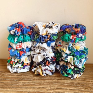 Set of sports themed fabric scrunchies with football and basketball prints on wooden table