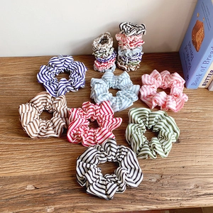 Colorful striped fabric scrunchies set in various vibrant colors on a wooden surface