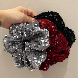 Three oversized velvet scrunchies with shiny sequins in black, grey, and burgundy colors