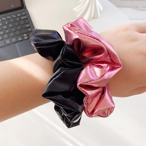 Stylish black and pink metallic faux leather scrunchies worn as elegant wrist accessories