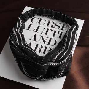 Cross-knot headband with black and white abstract geometric zig-zag pattern fabric