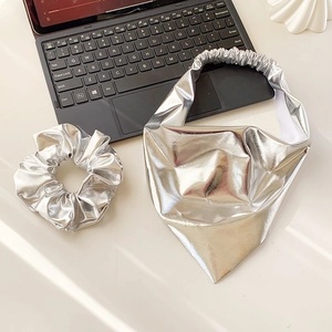 Macro shot of silver metallic scrunchie and triangular headband with shiny texture
