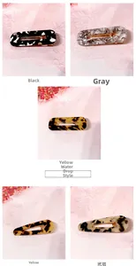 Detail of acetate hair clips with marble and tortoise shell patterns on lace background