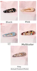 Close-up of five acetate drop hair clips with marble patterns and gold metal clips