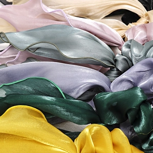 Close-up of premium satin hair scrunchies with pearlescent texture and soft sheen