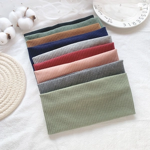 Knitted ribbed headbands in multiple colors stacked on a minimalist white tablecloth