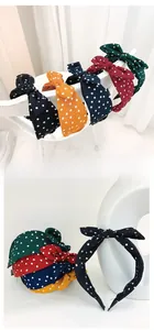 Vue détaillée de serre-têtes à pois avec nœud en tissus vert, rouge, marine et noir