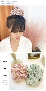 Detail showing oversized floral fabric scrunchies in pink and green patterns on a model