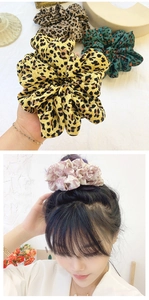 Macro detail of oversized leopard and floral print hair scrunchies with pleated fabric