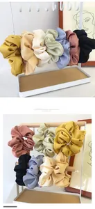 Gros plan de chouchous en satin assortis aux couleurs pastel et texture plissée