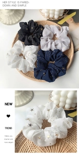Dettaglio degli elastici scrunchie in chiffon con motivi a stelle e dettagli in foglia oro