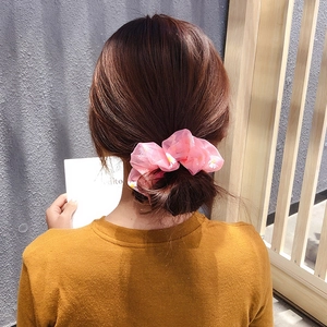 Pink daisy floral organza scrunchie tied on a hair bun for a stylish hair accessory
