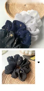 Vista dettagliata degli elastici in chiffon con stampa a stelle in bianco, blu e nero