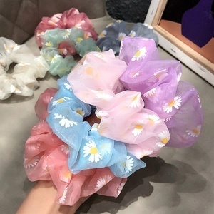 Close-up of lightweight organza daisy floral scrunchies in multiple pastel colors