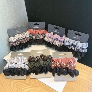 Detail view of silk satin hair scrunchies set featuring leopard print and solid patterns