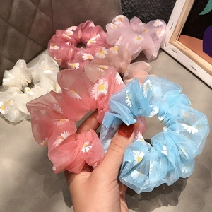 Detail of floral organza scrunchies with white daisy patterns in various pastel colors