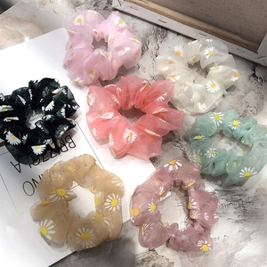 Floral daisy print organza scrunchies set in various colors on a marble surface