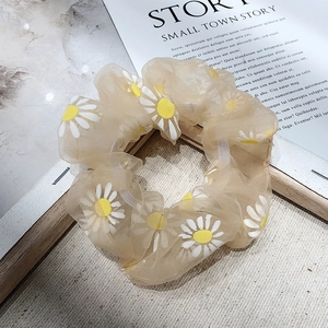 Cute daisy floral organza scrunchie hair tie for women on marble surface background
