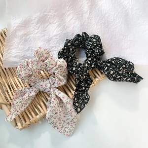 Florale Haar-Scrunchies mit langen Bändern auf einem dekorativen Bambustablett