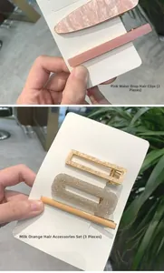 Dettaglio di set di fermagli per capelli in resina rosa e arancione con base in lega