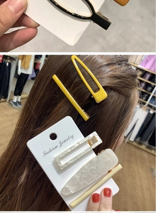 Dettaglio del set di 5 fermagli per capelli colorati con resina marmorizzata e clip gialle