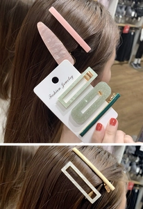 Dettaglio di fermagli per capelli colorati in acetato in varie forme geometriche