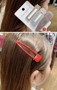 Dettaglio di fermagli per capelli in resina colorata e una clip rossa sui capelli