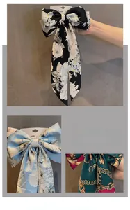 Détail de pinces à cheveux nœud avec rubans à fleurs et motifs de chaînes dorées