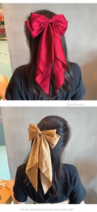 Détail de barrettes à nœud en satin rouge vin et champagne avec de longs rubans