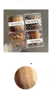 Detailed macro view showing diverse textures of elastic braided and plush hair ties in a box