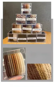 Close-up of elastic hair bands in earthy tones and various textures in clear box