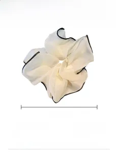 Vista dettagliata di un elastico in organza crema da 15 cm con bordo nero e dimensioni
