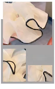 Dettaglio di un elastico in chiffon beige con cuciture nere a contrasto e mesh