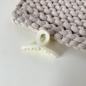 Elegant cream minimalist hair claw clip with crossed twist design for women styling