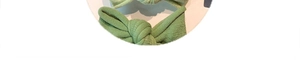 Detail einer grünen gestrickten Haarschleife mit geripptem Stoff und Mittelknoten