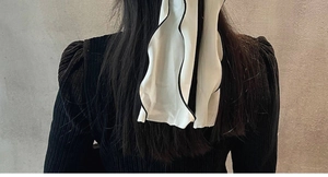 Gros plan d'un chouchou ruban blanc avec bordure festonnée noire sur cheveux longs
