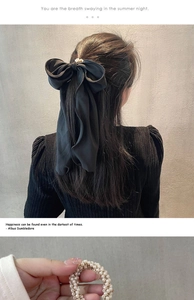 Détail d'un chouchou noeud en tissu noir élégant et d'un élastique perles