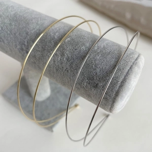 Minimalist gold and silver metal headbands set of four on a grey velvet display stand