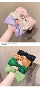 Détail de plusieurs serre-têtes à nœuds en satin rose, vert et champagne en tissu de soie