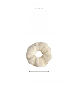 Gros plan d'un chouchou en peluche crème avec une texture douce et une bande élastique
