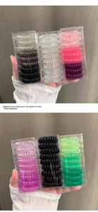 Gros plan de 9 élastiques à cheveux spirales dégradés dans une boîte de rangement