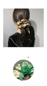 Detail of plaid oversized scrunchies in brown and green with soft flannel texture