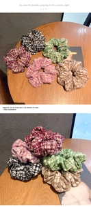 Detail shot of five houndstooth knitted hair scrunchies in various vintage colors